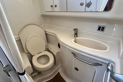 Slide: The Image of 2008 Sea Ray 340 Sundancer bathroom with toilet, sink, and storage cabinets. - 25