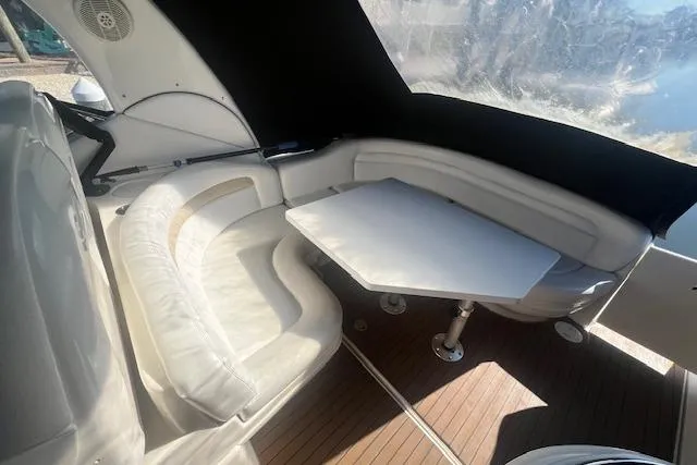 Slide: The Image of 2008 Sea Ray 340 Sundancer interior with white seating and table, featuring wood flooring. - 9