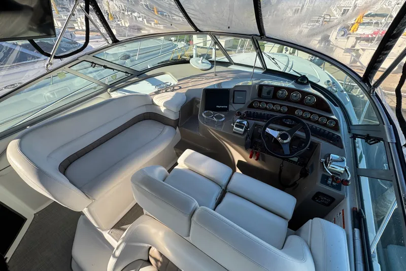 Slide: The Image of 2004 Four Winns 378 Vista boat cockpit with steering wheel and seating area. - 12