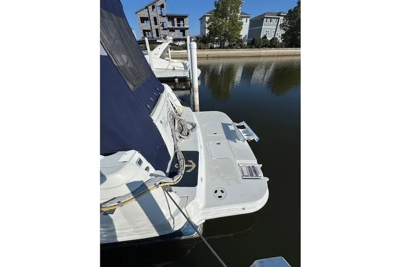 Slide: The Image of 2004 Four Winns 378 Vista yacht docked at marina, featuring blue canopy and white deck. - 16