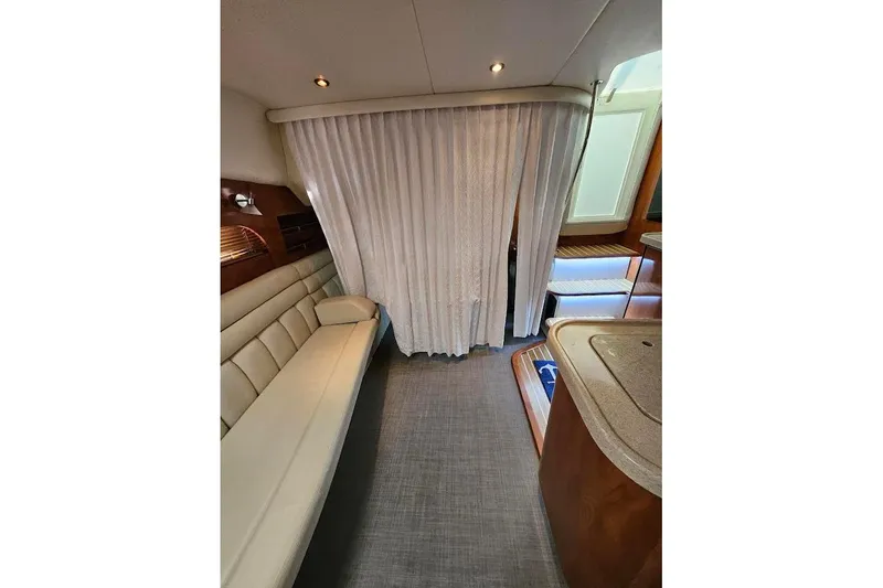 Slide: The Image of Interior of 2004 Four Winns 378 Vista yacht with beige seating and curtain divider. - 26