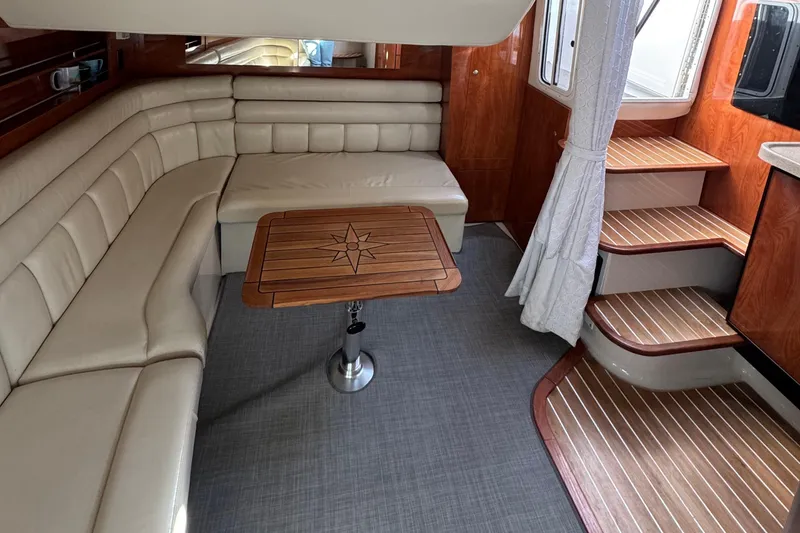Slide: The Image of Luxurious interior of 2004 Four Winns 378 Vista yacht with elegant seating and wooden table. - 9