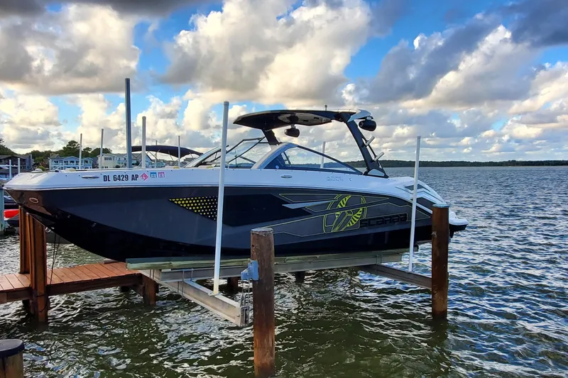 The Image of 2024 Scarab 285 Wake ID boat docked on a lake under a cloudy sky. - 0