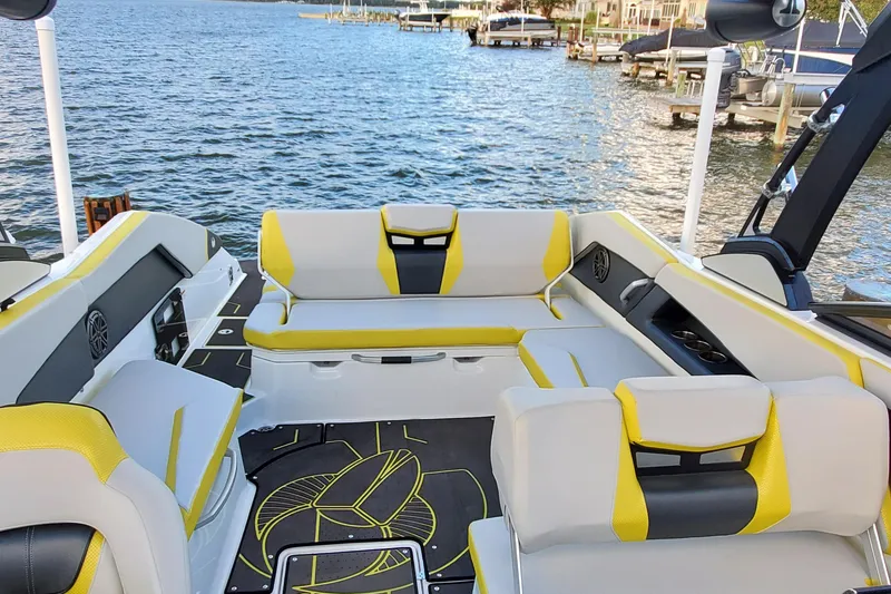 Slide: The Image of 2024 Scarab 285 Wake ID boat interior with yellow and gray seating, docked by the water. - 20