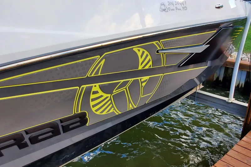 Slide: The Image of 2024 Scarab 285 Wake ID boat with sleek graphics docked by the water. - 31