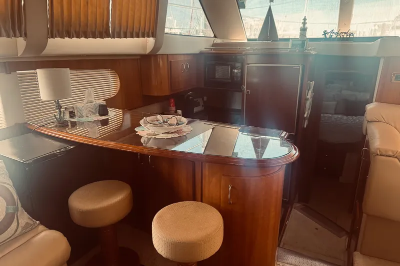 Slide: The Image of Interior of 2005 Carver 466 Motor Yacht with wooden bar and seating area. - 17