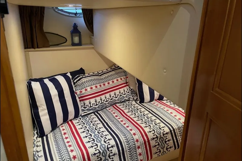 Slide: The Image of Cozy cabin interior of 2005 Carver 466 Motor Yacht with nautical-themed bedding. - 13