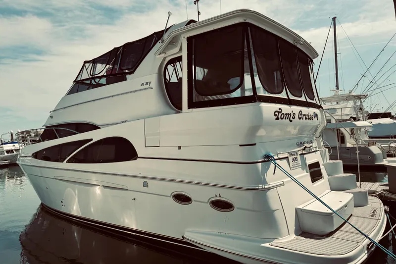 Slide: The Image of 2005 Carver 466 Motor Yacht docked at marina, featuring sleek design and spacious upper deck. - 44