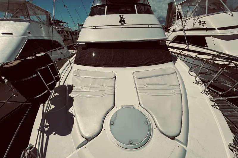 Slide: The Image of 2005 Carver 466 Motor Yacht docked, showcasing sleek design and spacious deck. - 5