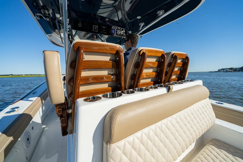 Slide: The Image of 2023 Valhalla Boatworks V-37 interior with luxurious seating and cup holders on a sunny day. - 18