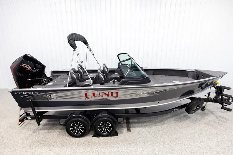 The Image of 2026 Lund 2075 Impact XS fishing boat on trailer, side view in showroom. - 1