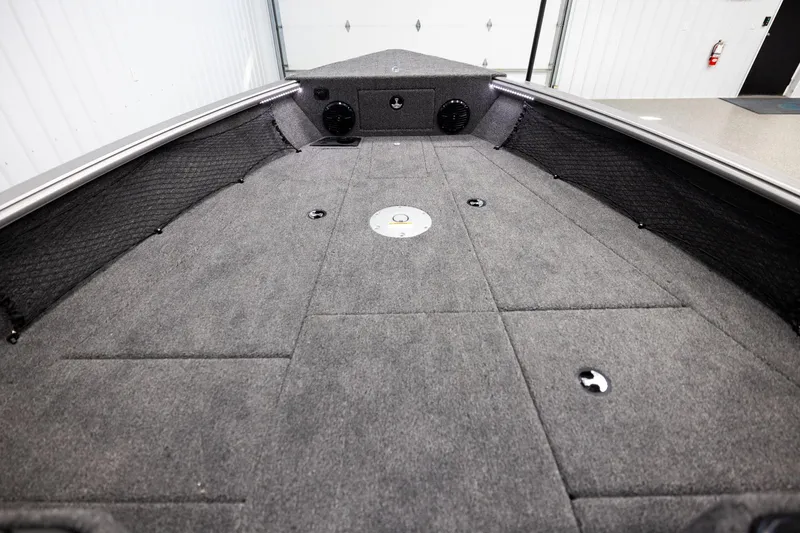 Slide: The Image of 2026 Lund 2075 Impact XS boat interior with carpeted deck and storage compartments. - 14