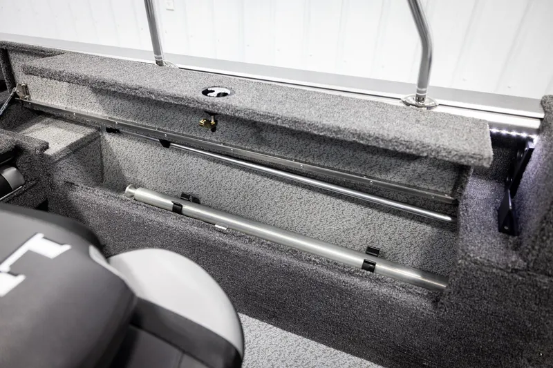 Slide: The Image of 2026 Lund 2075 Impact XS boat interior storage compartment with rod holders. - 30