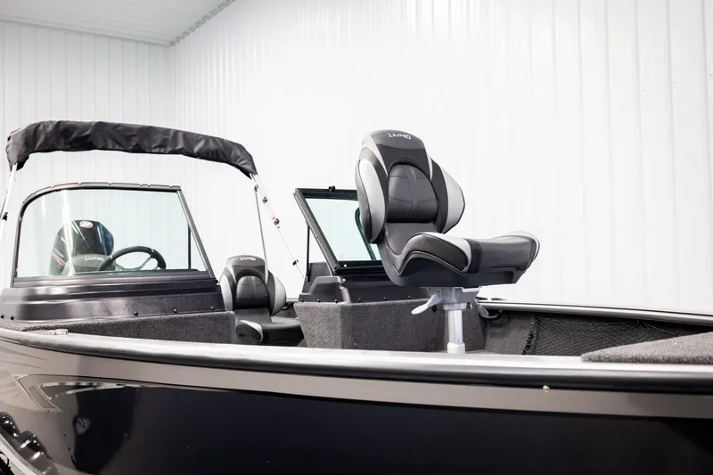 Slide: The Image of 2026 Lund 2075 Impact XS boat interior with seating and windshield in a showroom. - 32