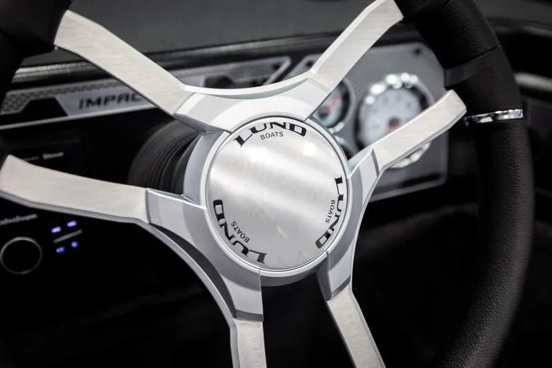 Slide: The Image of Steering wheel of 2026 Lund 2075 Impact XS boat, featuring sleek metallic design. - 35
