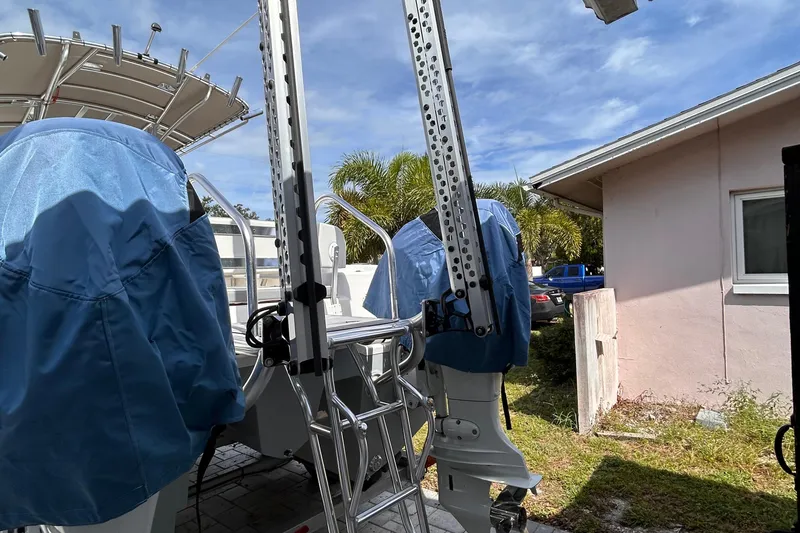 Slide: The Image of 2023 Falcon Boats F22 with covered engines, parked near a house under a clear sky. - 10