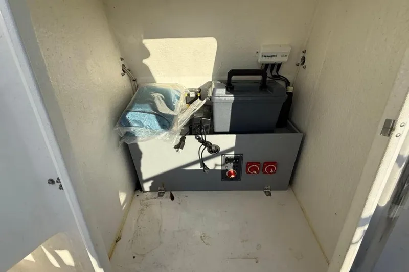 Slide: The Image of Electrical compartment of 2023 Falcon Boats F22, featuring battery and control panel. - 18