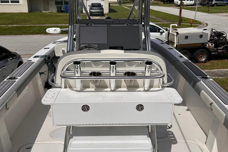 Slide: The Image of 2023 Falcon Boats F22 interior with rod holders and storage, parked on a residential street. - 8