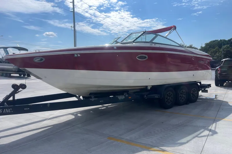 Slide: The Image of Red and white 2004 Cobalt 282 boat on a trailer under a clear blue sky. - 10