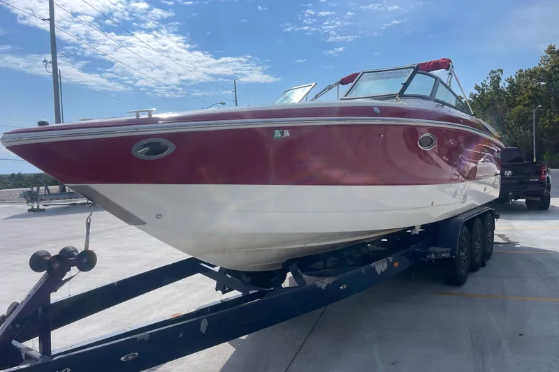 Slide: The Image of 2004 Cobalt 282 boat on trailer, red and white design, parked outdoors. - 11