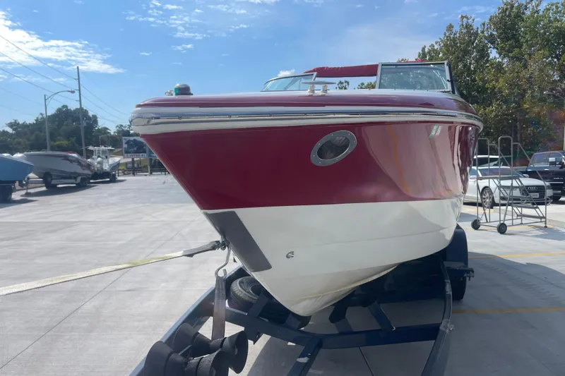 Slide: The Image of 2004 Cobalt 282 boat on trailer, red and white hull, parked outdoors. - 12