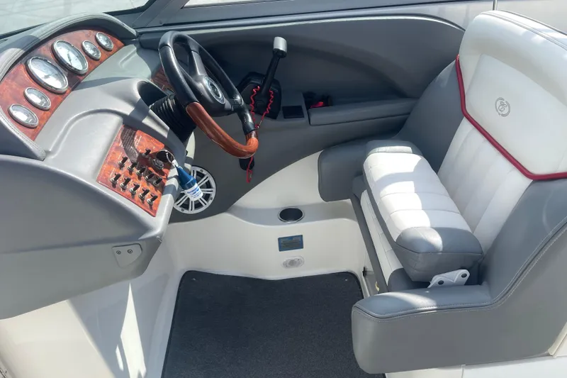 Slide: The Image of 2004 Cobalt 282 boat cockpit with steering wheel, gauges, and cushioned seat. - 19