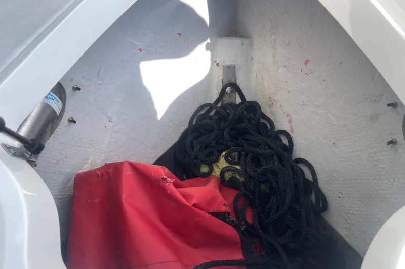 Slide: The Image of Storage compartment of 2004 Cobalt 282 boat with black rope and red cover. - 22