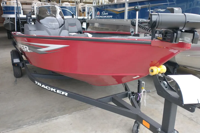 The Image of 2026 Tracker Super Guide V-16 SC boat in red on trailer, indoor showroom. - 0