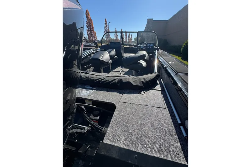 Slide: The Image of 2026 Tracker Targa V-19 Combo boat interior with seating and dashboard, parked outdoors. - 5