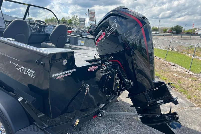 Slide: The Image of 2026 Tracker Pro Guide V-175 Combo boat with powerful outboard motor, parked outdoors. - 12