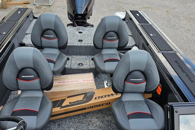 Slide: The Image of 2026 Tracker Targa V-19 Combo boat interior with four gray seats and a cardboard box. - 10