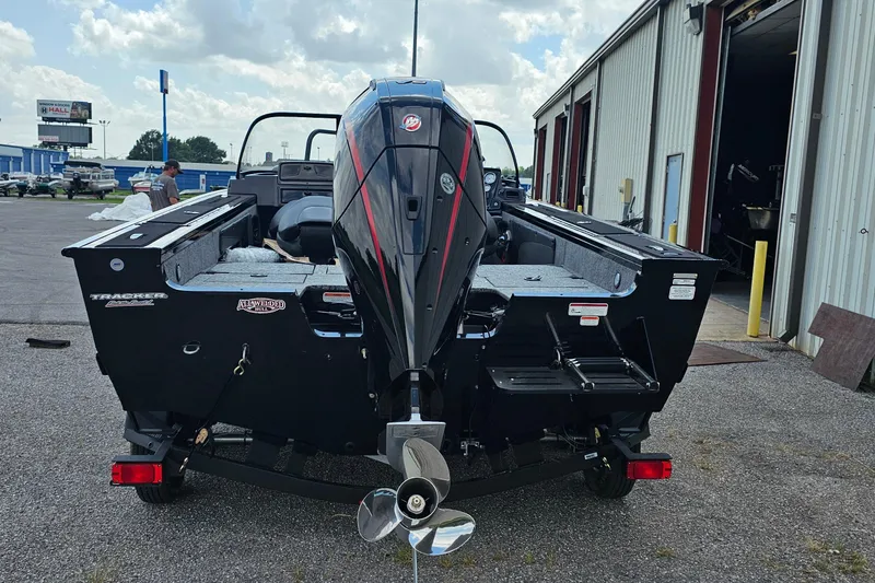 Slide: The Image of 2026 Tracker Targa V-19 Combo boat, rear view, parked outside a warehouse. - 3