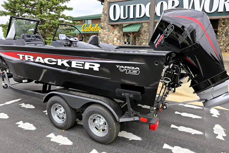 Slide: The Image of 2026 Tracker Targa V-19 Combo boat on trailer, parked outside Cabela's store. - 2