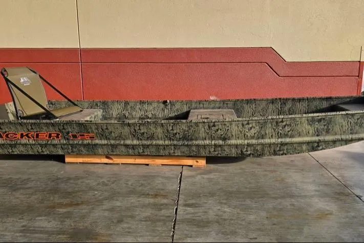 The Image of 2026 Tracker Grizzly 15 Jon boat with camouflage design, displayed outdoors. - 0