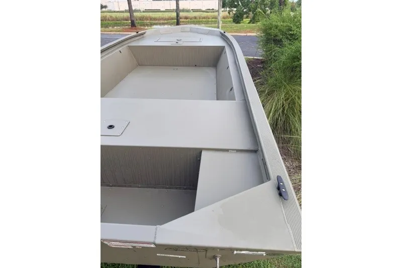 Slide: The Image of 2026 Tracker Grizzly 1648 Utility boat, spacious interior, parked outdoors. - 4
