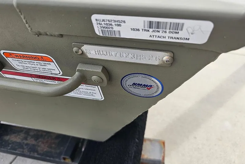 Slide: The Image of 2026 Tracker Grizzly 10 Jon boat transom with warning labels and certification sticker. - 5