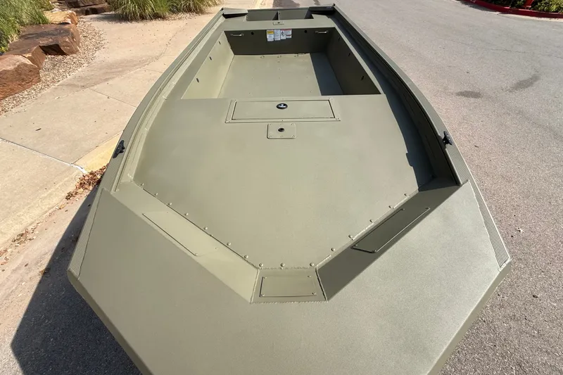 Slide: The Image of 2026 Tracker Grizzly 1754 Utility boat, olive green, parked on a concrete surface. - 2
