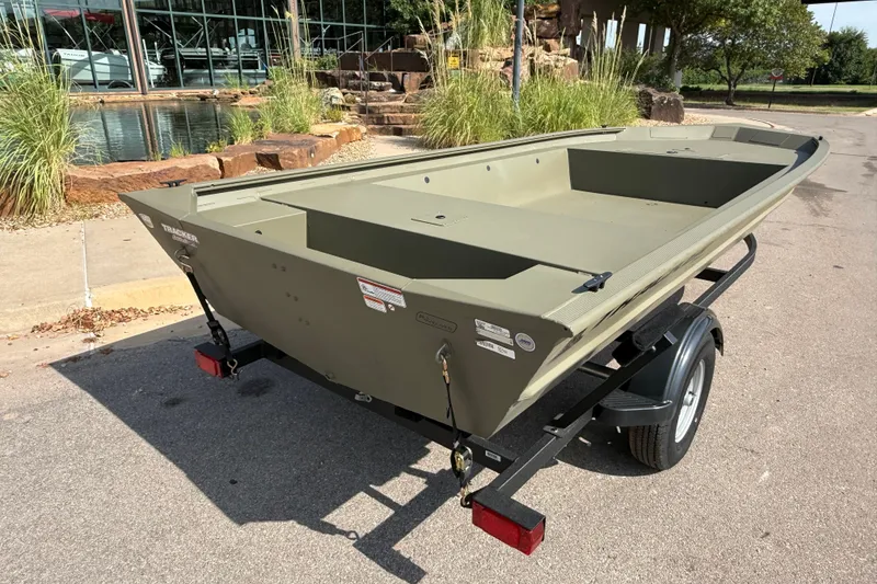 Slide: The Image of 2026 Tracker Grizzly 1754 Utility boat on trailer, parked outdoors near a pond. - 6