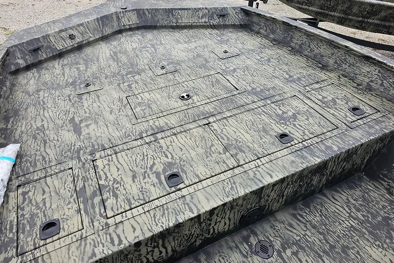 Slide: The Image of 2026 Tracker Grizzly 2072 CC boat deck with camo pattern and storage compartments. - 13