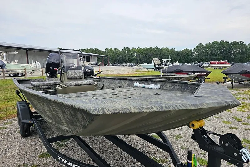 Slide: The Image of 2026 Tracker Grizzly 2072 CC boat on trailer, parked outdoors near other boats. - 5