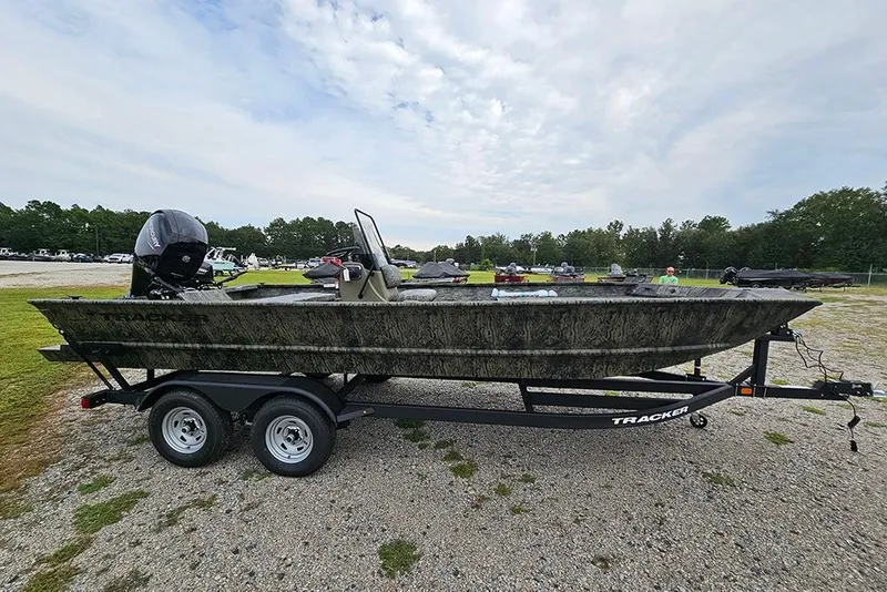 Slide: The Image of 2026 Tracker Grizzly 2072 CC boat on trailer, parked outdoors under cloudy sky. - 6