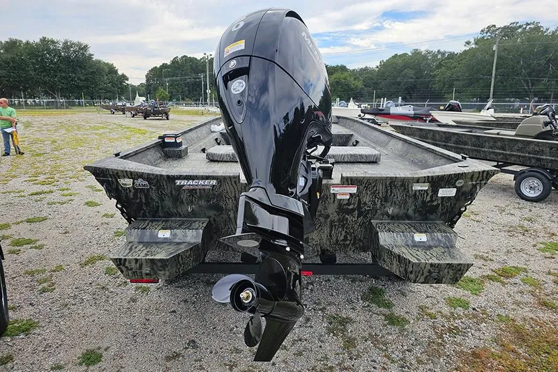 Slide: The Image of 2026 Tracker Grizzly 2072 CC boat with powerful outboard motor in a parking area. - 8