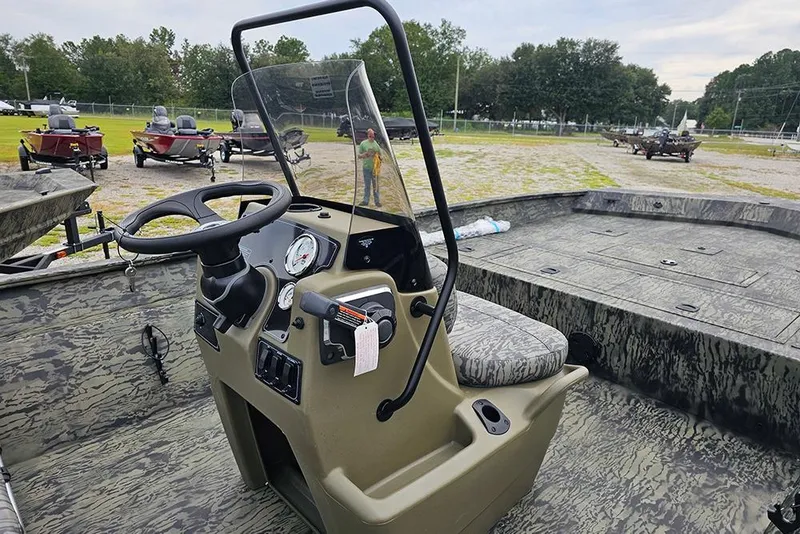 Slide: The Image of 2026 Tracker Grizzly 2072 CC boat interior with steering console and camouflage design. - 9