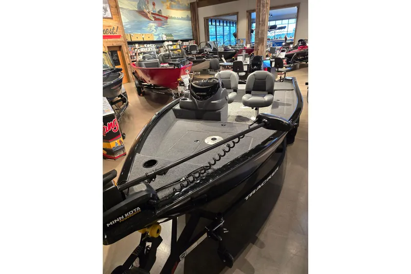 Slide: The Image of 2026 Tracker Super Guide V-16 SC fishing boat displayed in showroom with seating and equipment. - 44