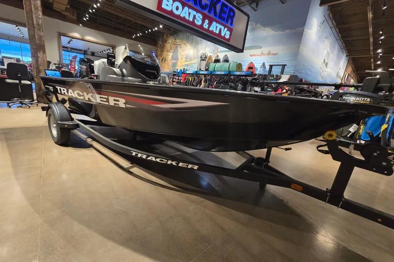 Slide: The Image of 2026 Tracker Super Guide V-16 SC boat displayed in a showroom. - 43