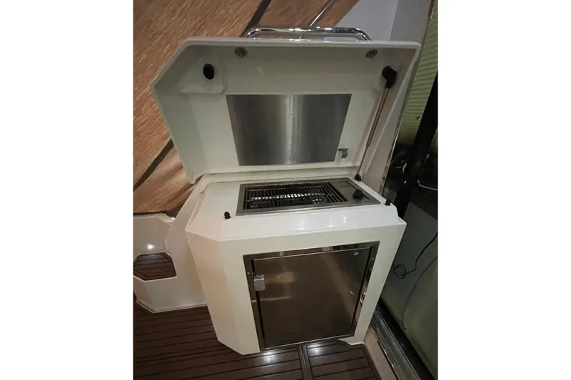 Slide: The Image of 2012 Cruisers Yachts 48 Cantius on dock, featuring outdoor seating and American flag. - 19