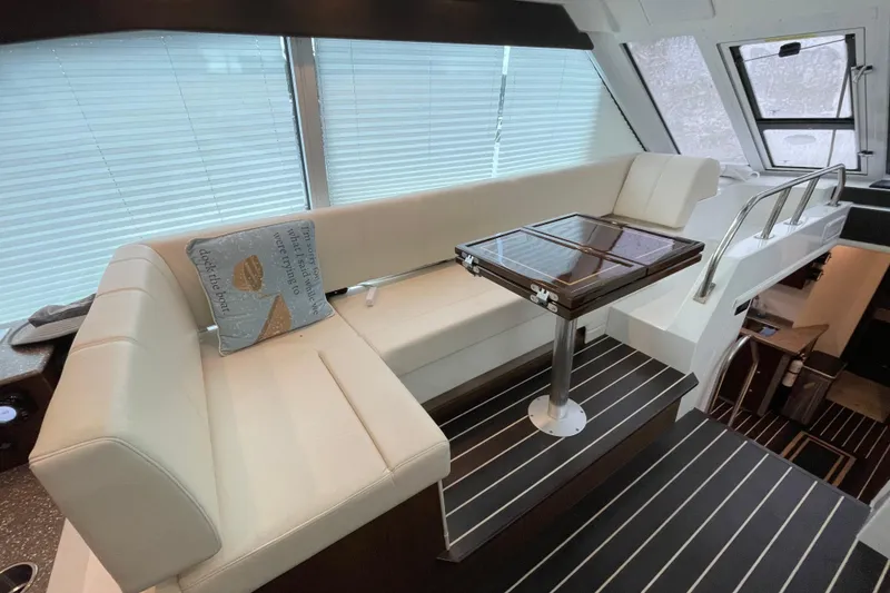 Slide: The Image of 2012 Cruisers Yachts 48 Cantius deck with white seating and table, docked by water. - 20