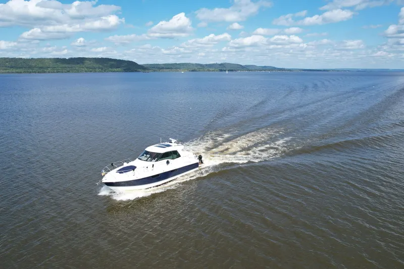 Slide: The Image of 2012 Cruisers Yachts 48 Cantius cruising on a vast, serene lake under a blue sky. - 4