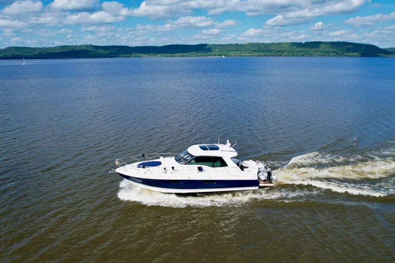 Slide: The Image of 2012 Cruisers Yachts 48 Cantius cruising on a serene lake under a blue sky. - 5