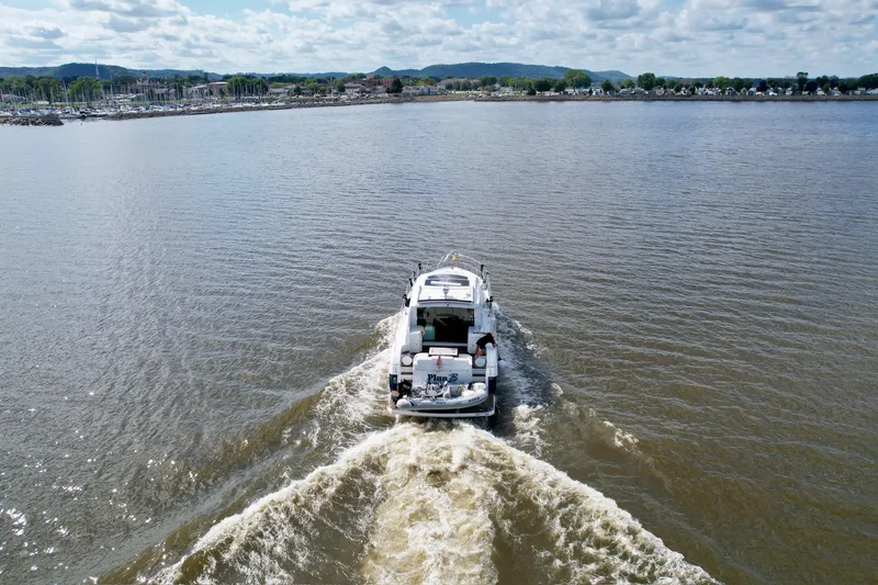 Slide: The Image of 2012 Cruisers Yachts 48 Cantius sailing on a calm lake under a cloudy sky. - 7